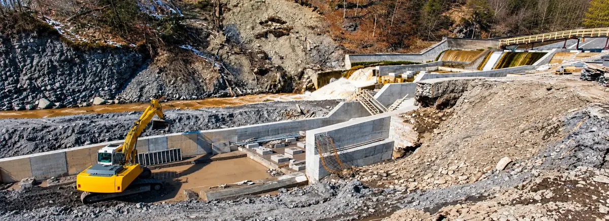 Excavator working at a dam spillway construction site