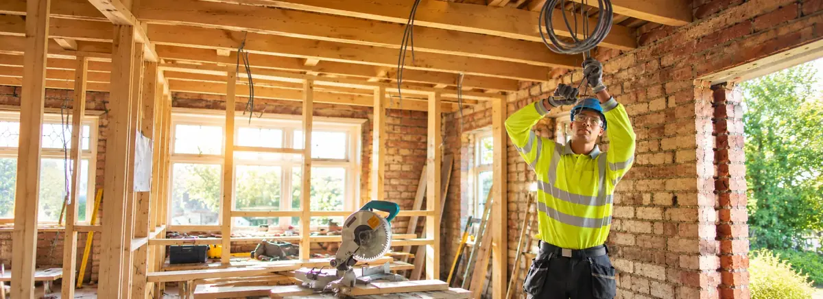 Electrician installing wiring in a building under construction