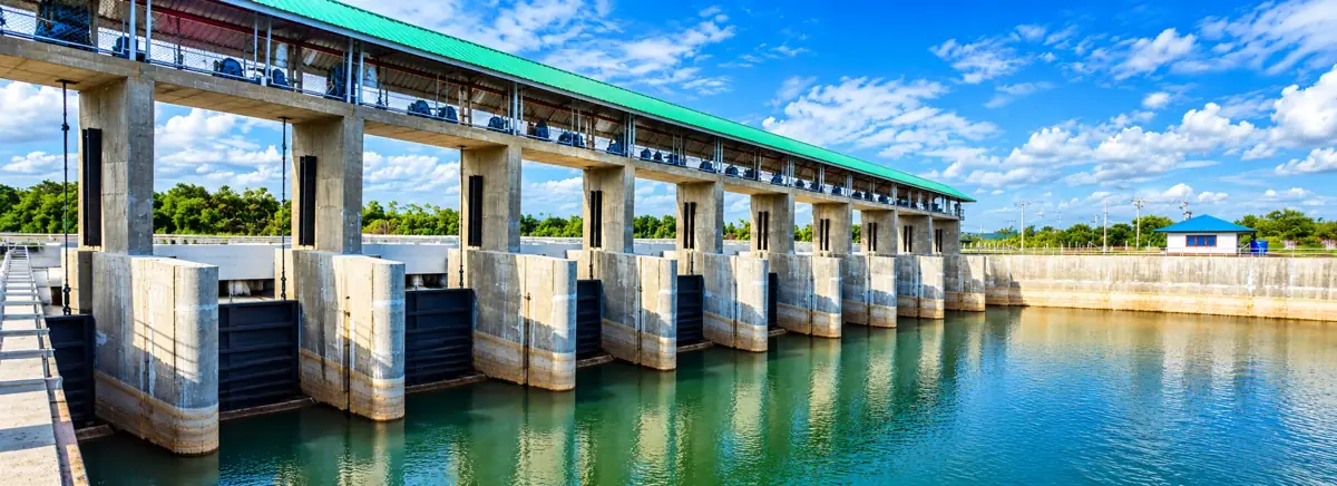 Concrete flood control structure with gates beside a river